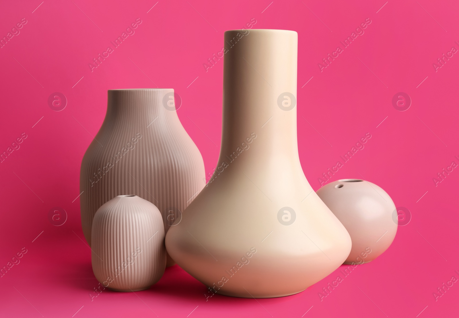 Photo of Stylish empty ceramic vases on pink background