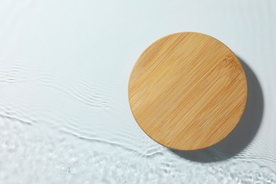 Photo of Presentation of product. Wooden podium in water on white background, top view. Space for text