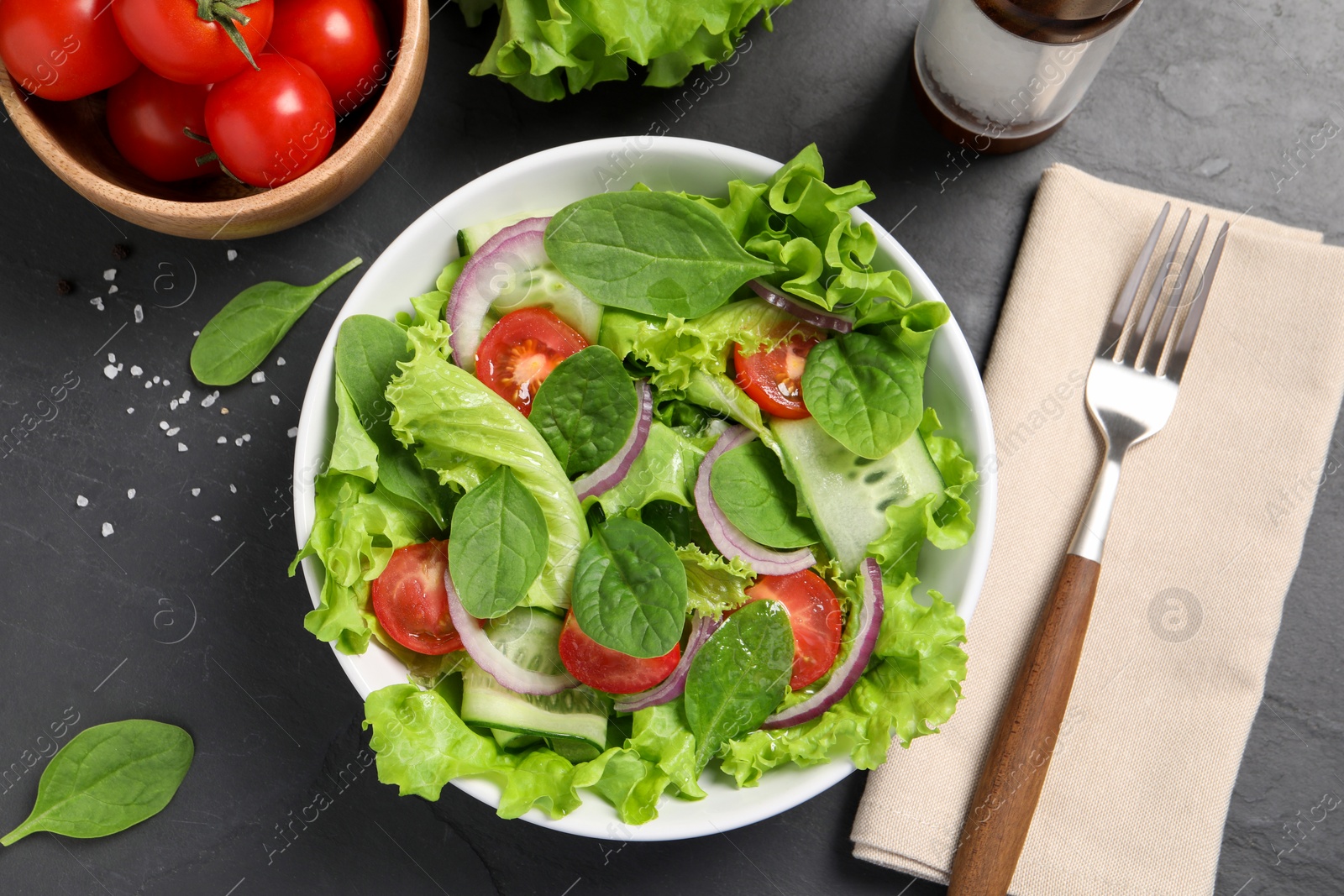 Photo of Delicious vegetable salad served on grey table, flat lay