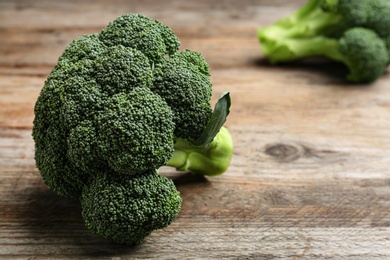 Photo of Fresh broccoli on wooden table, closeup with space for text