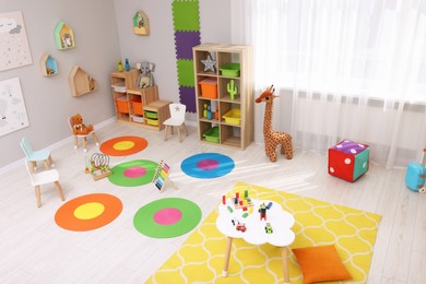 Child`s playroom with different toys and furniture, above view. Cozy kindergarten interior