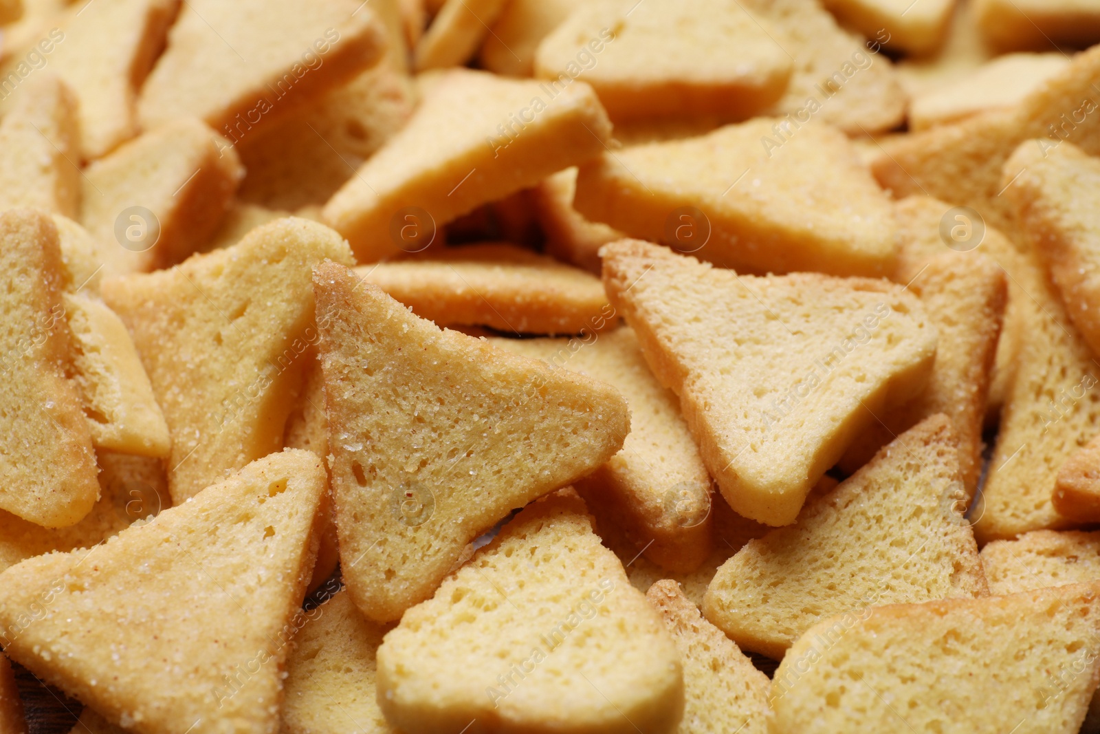 Photo of Heap of crispy rusks as background, closeup