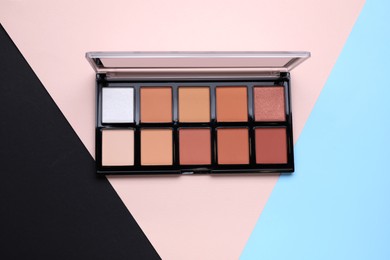 Photo of Contouring palette on color background, top view. Professional cosmetic product