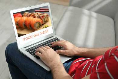 Image of Man using laptop for online food order during quarantine, closeup. Delivery service