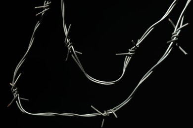 Metal barbed wire on black background, closeup