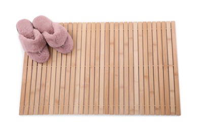 Bamboo rug with stylish soft slippers isolated on white, top view. Bath accessory