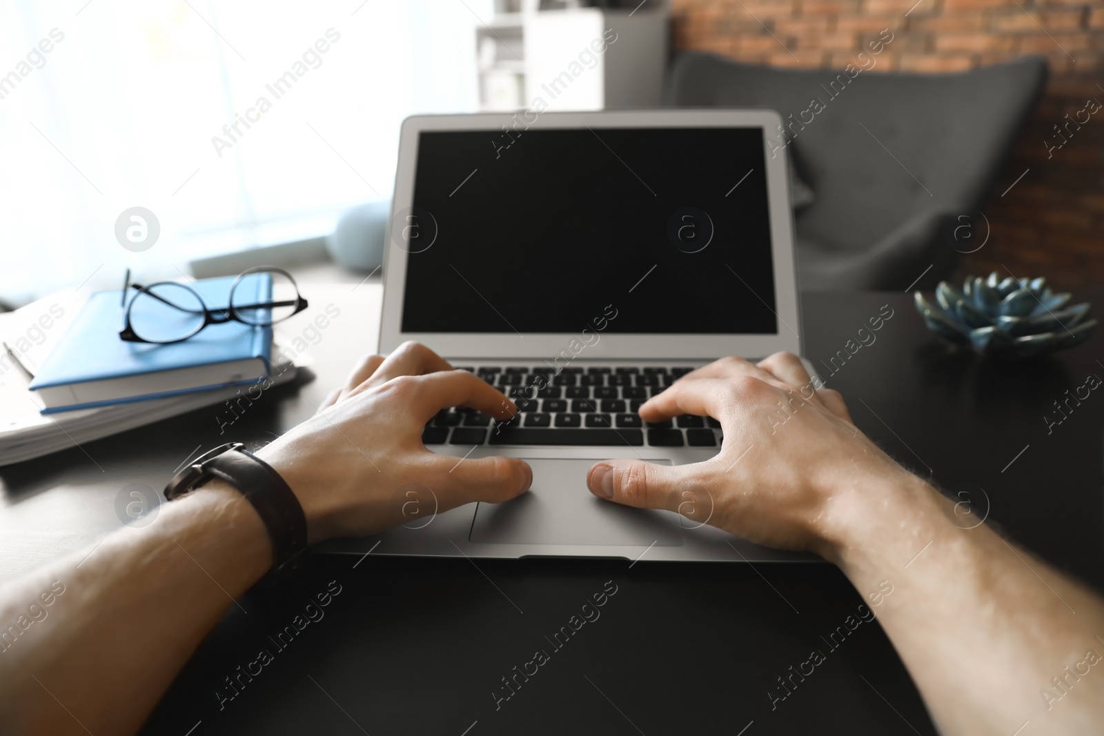 Photo of Man using laptop at table indoors, closeup. Space for text