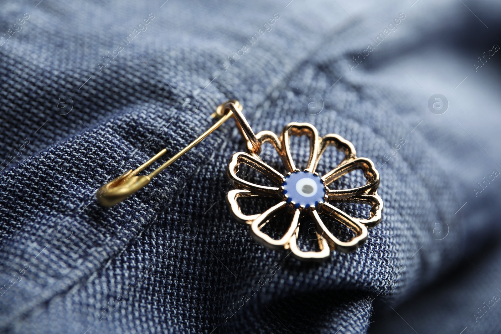 Photo of Evil eye safety pin on clothing, closeup