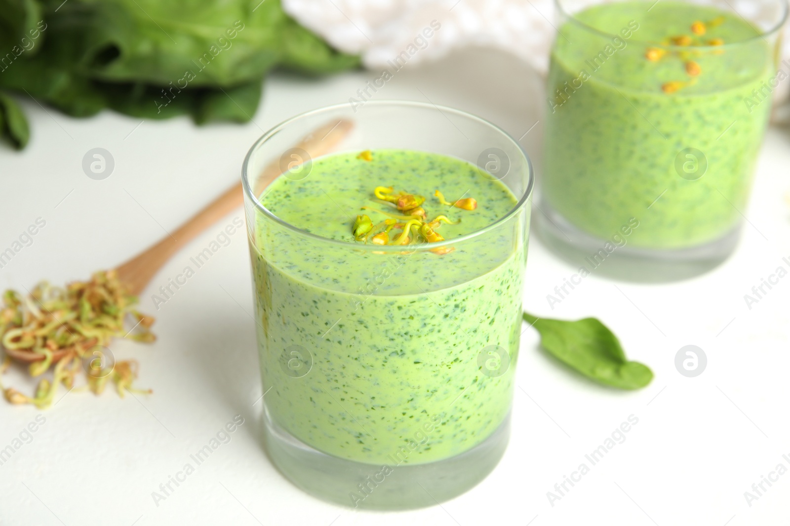 Photo of Green buckwheat smoothie on white table, closeup