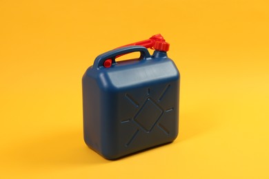 Photo of Blue plastic canister with tube on orange background