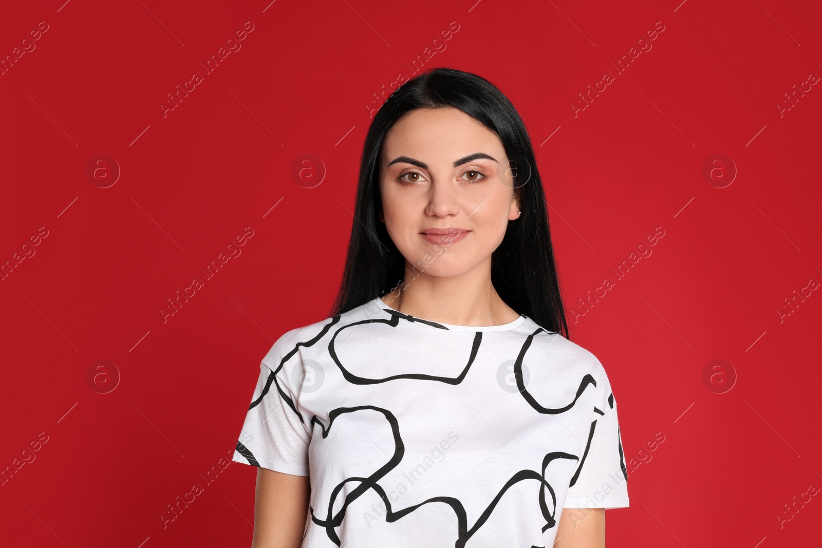 Photo of Portrait of beautiful young woman on red background