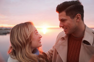 Photo of Couple looking at each other near river on sunset