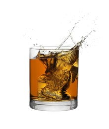 Photo of Whiskey splashing out of glass on white background