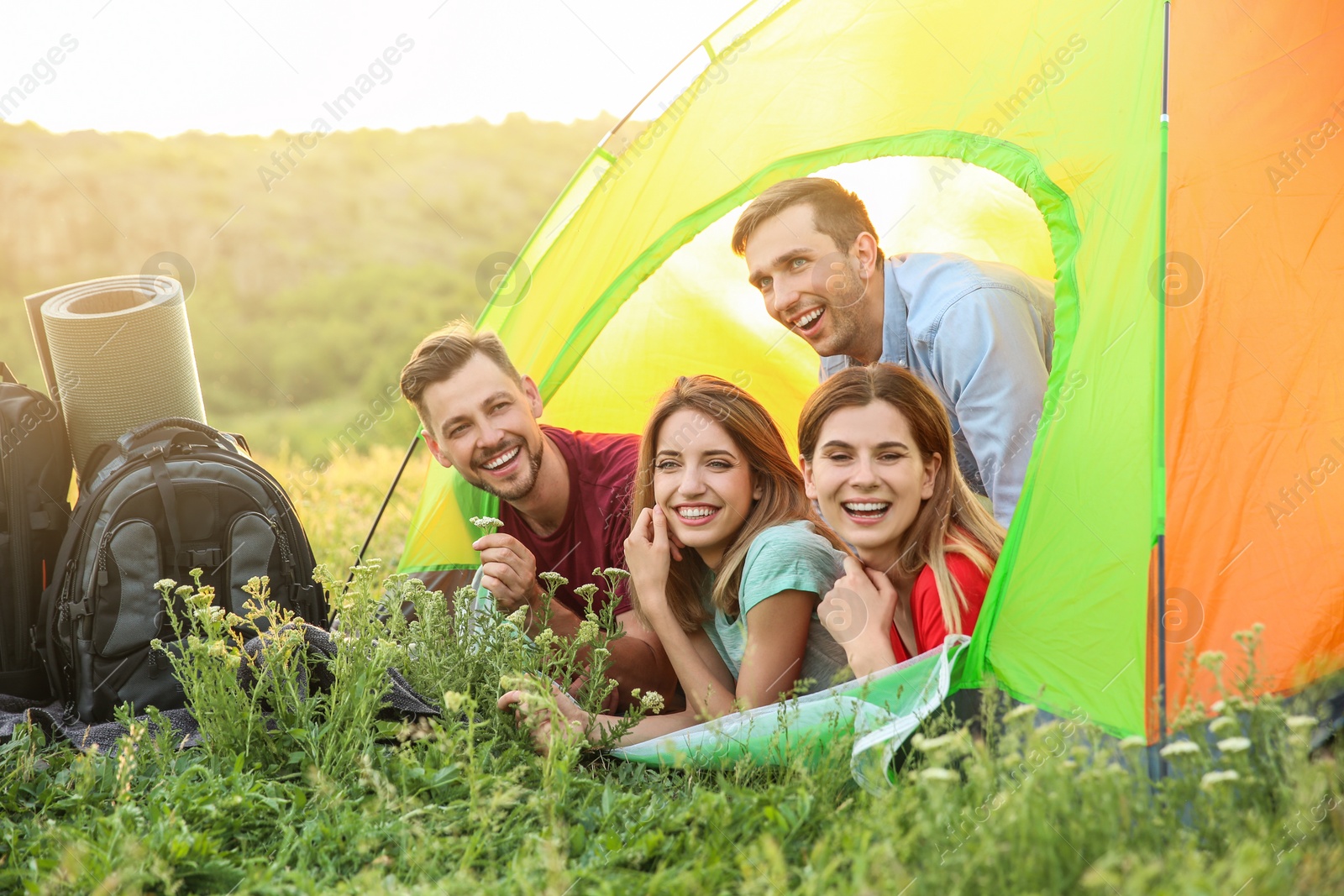 Photo of Group of happy young people in camping tent