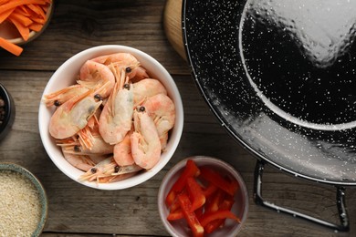 Photo of Flat lay composition with black wok and products on wooden table