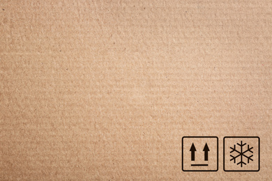 Image of Cardboard box with packaging symbols as background, closeup