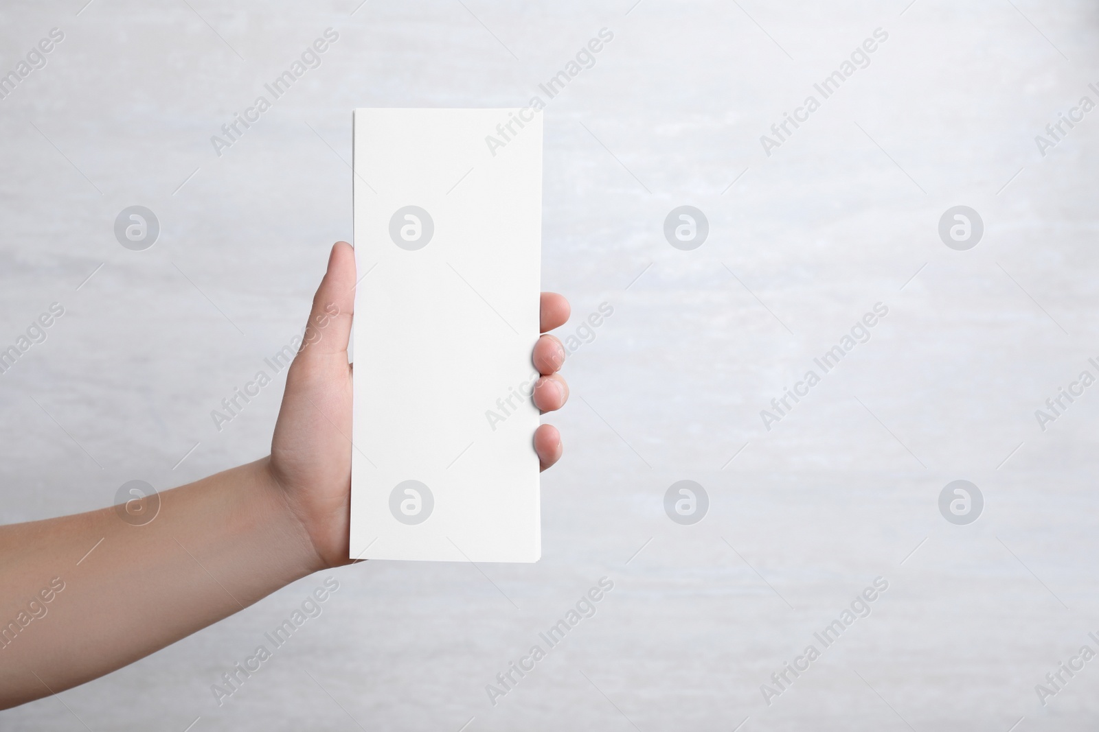 Photo of Man holding blank palm cards on light background. Mock up for design