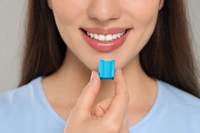 Woman with bubble gum on color background, closeup