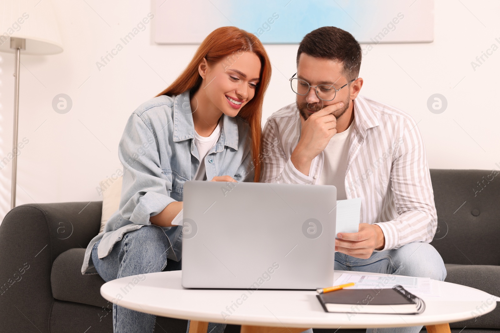 Photo of Couple doing taxes at table in living room