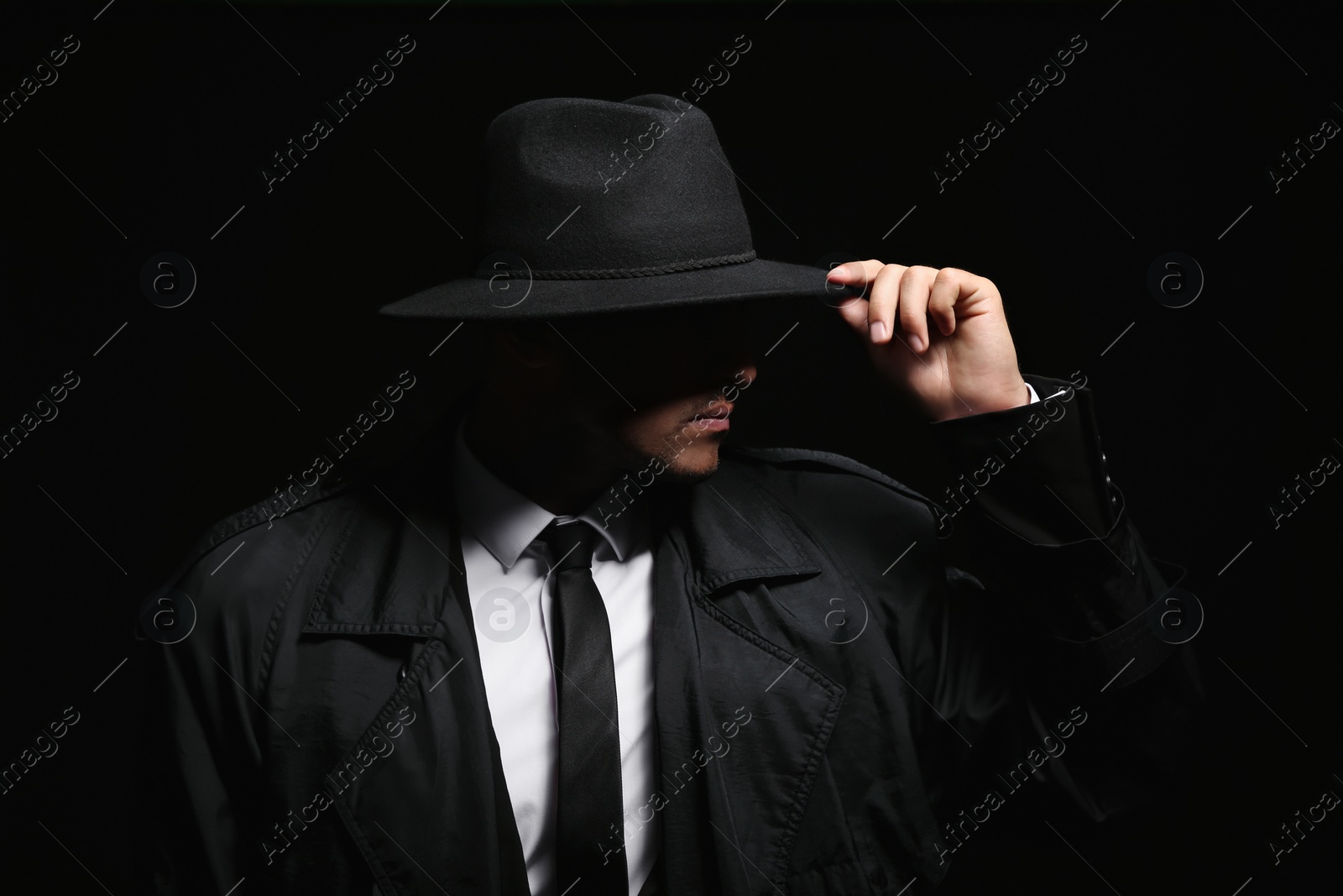 Photo of Old fashioned detective in hat on dark background