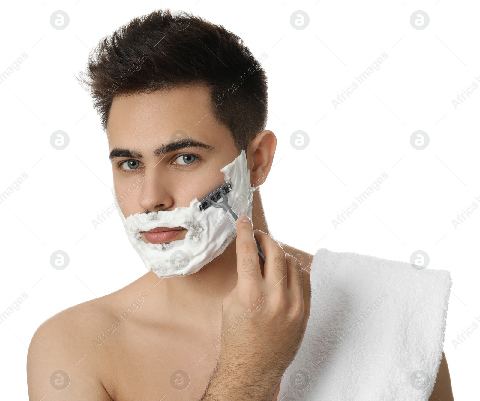 Photo of Handsome young man shaving with razor on white background