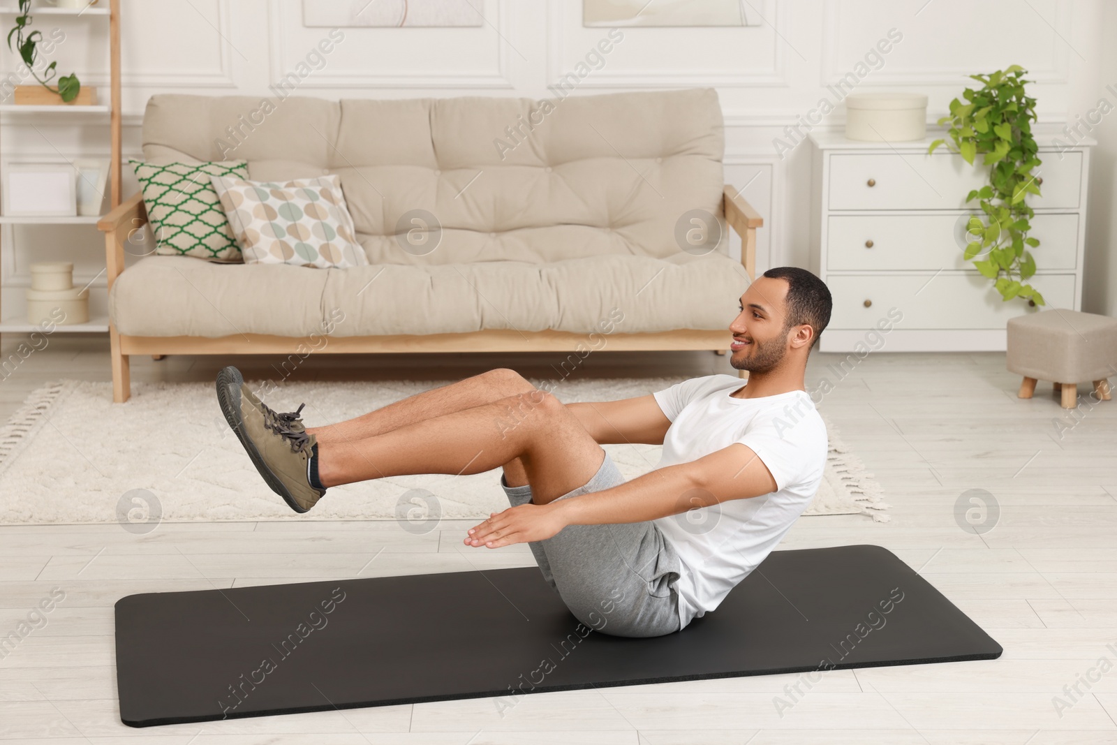 Photo of Man doing morning exercise on fitness mat at home