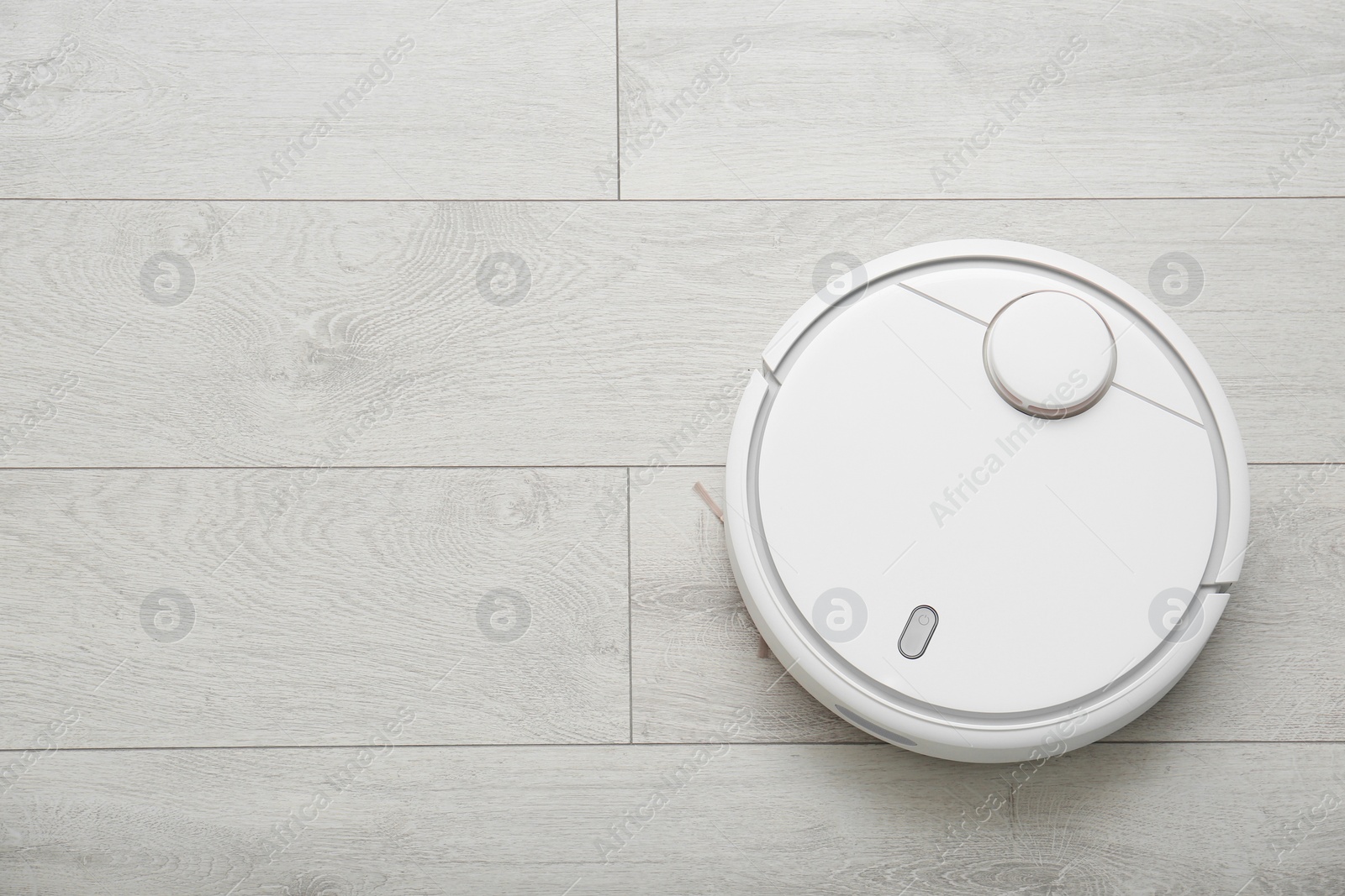 Photo of Hoovering floor with modern robotic vacuum cleaner indoors, top view. Space for text