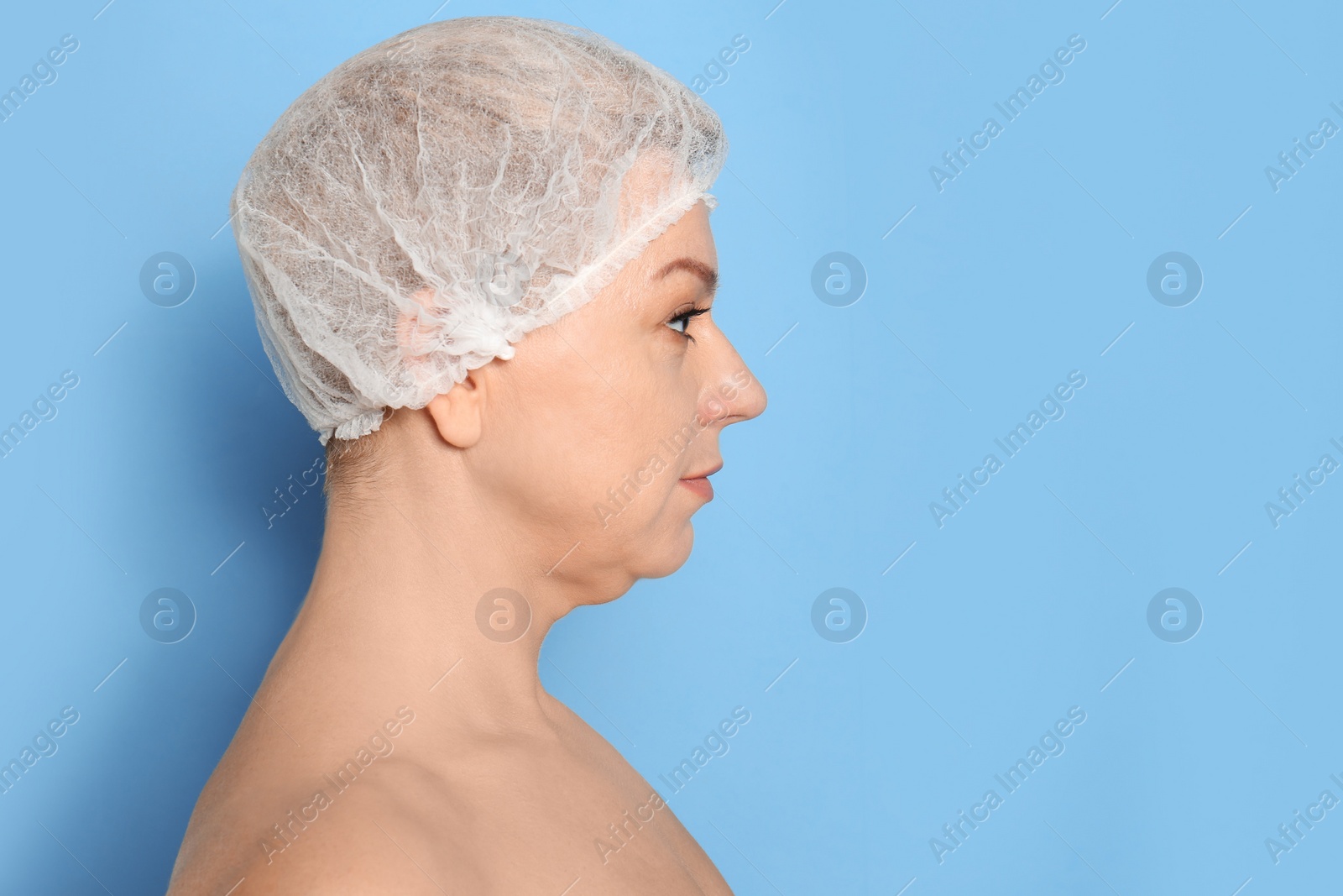 Photo of Mature woman with double chin on blue background. Space for text