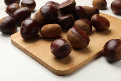 Sweet fresh edible chestnuts on white table, closeup