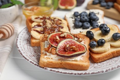 Photo of Different sweet delicious toasts on plate, closeup