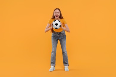 Photo of Emotional sports fan with ball on yellow background