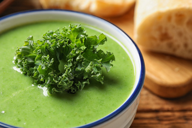 Tasty kale soup on wooden table, closeup