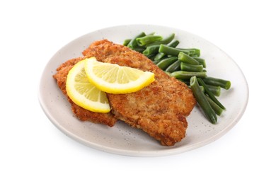 Photo of Plate of tasty schnitzels with lemon and green beans isolated on white