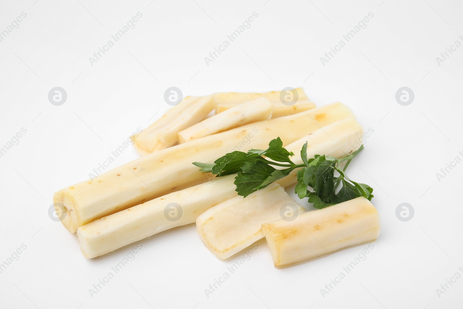 Photo of Cut raw salsify roots and parsley on white background