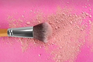 Photo of Makeup brush and scattered blush on bright pink background, top view