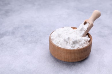 Photo of Scoop and bowl of starch on light gray table, closeup. Space for text