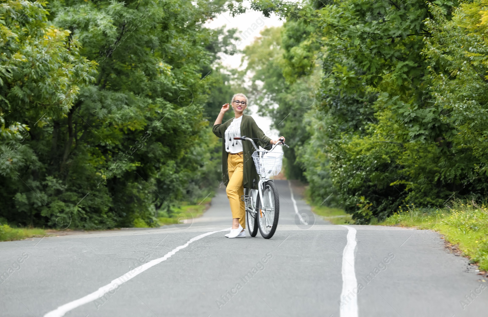 Photo of Beautiful woman in casual outfit with bicycle outdoors