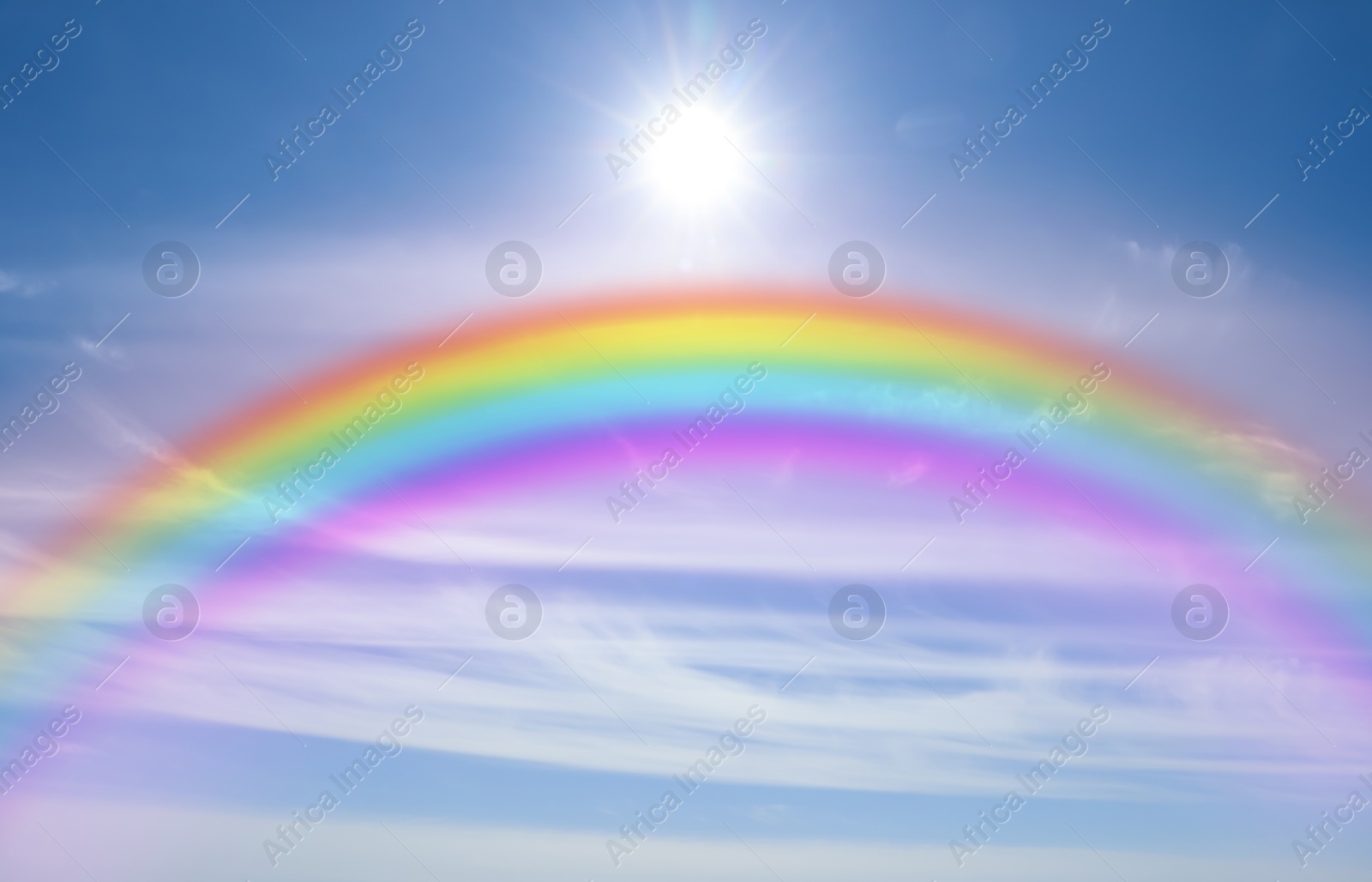 Image of Beautiful view of bright rainbow in blue sky on sunny day