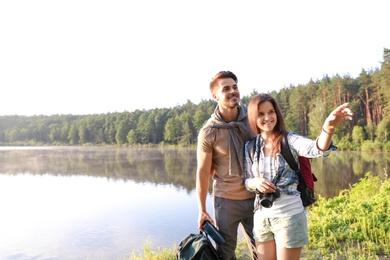 Young couple on shore of beautiful lake. Camping season