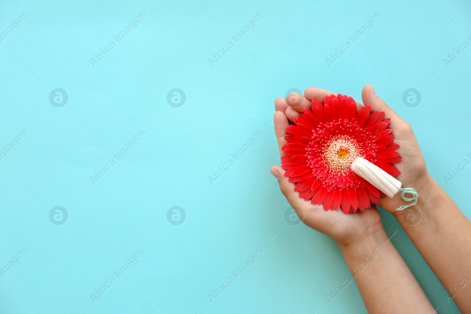 Photo of Woman holding flower and tampon on color background, top view. Gynecological care