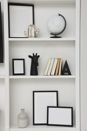 Books and different decorative elements on shelving unit indoors