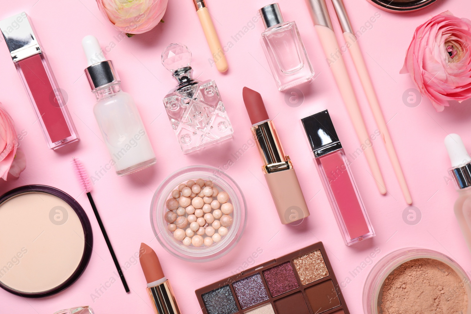 Photo of Flat lay composition with different makeup products and beautiful spring flowers on pink background