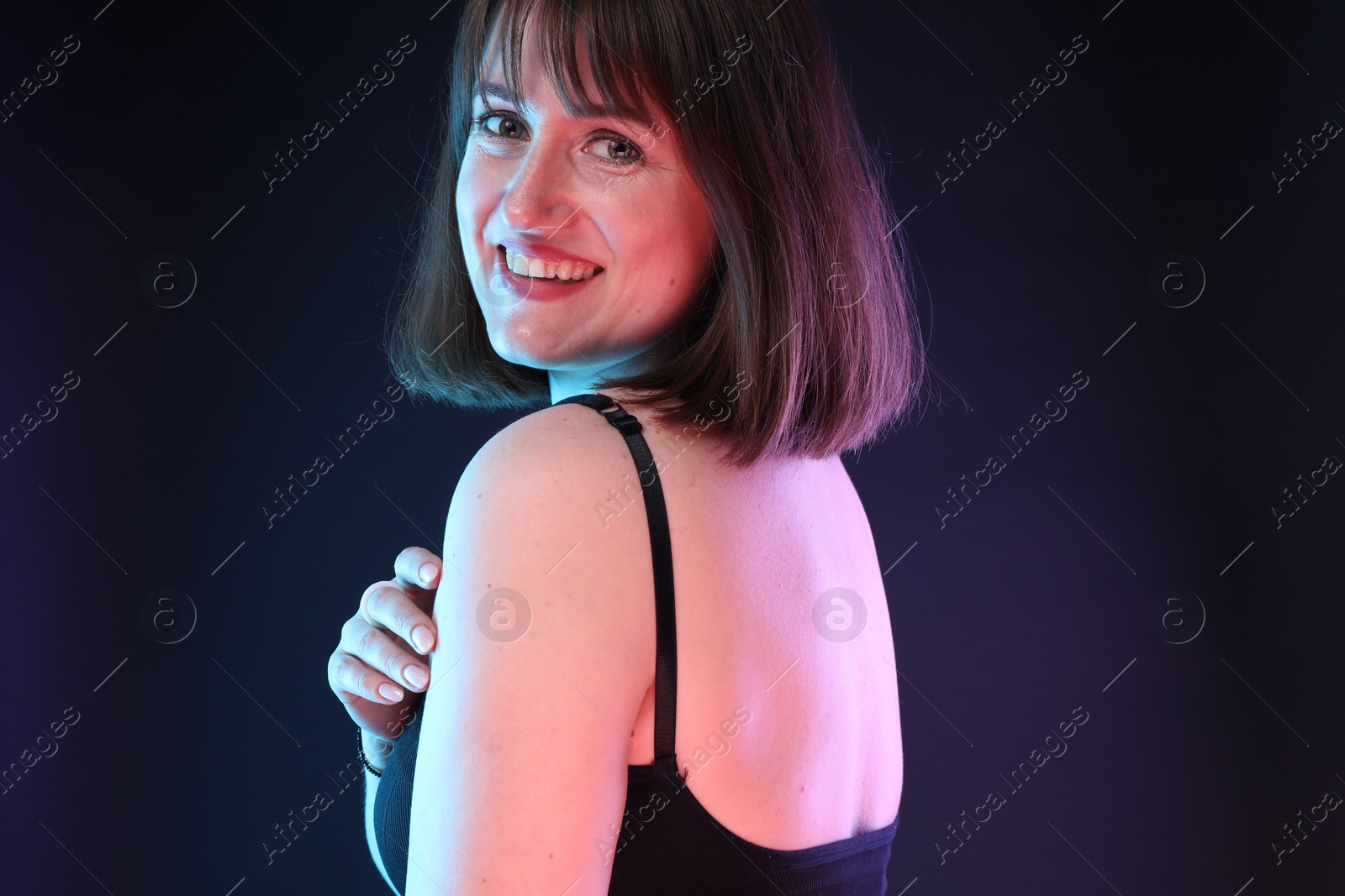 Photo of Portrait of happy woman on dark background