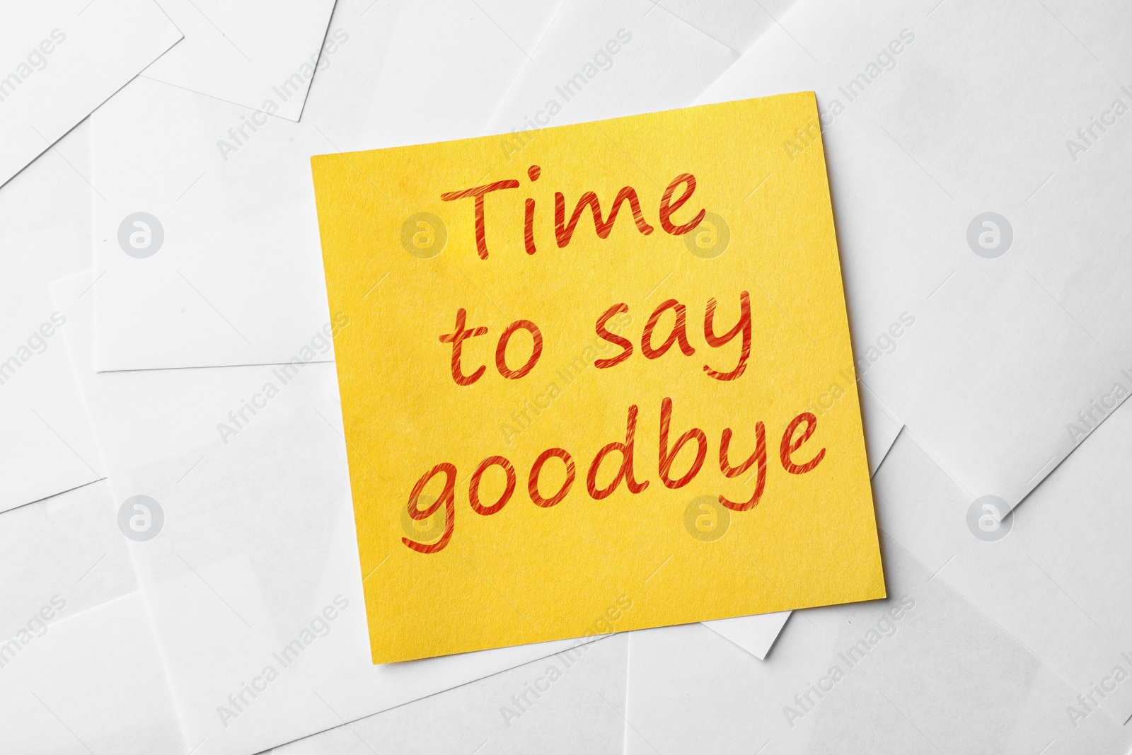 Image of Note with phrase Time to say goodbye on paper sheets, top view