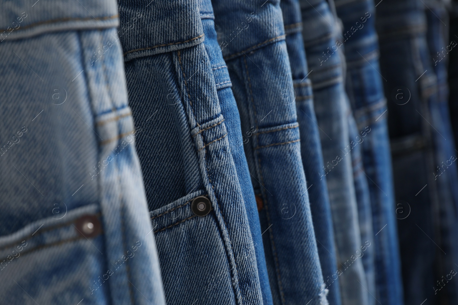 Photo of Different stylish blue jeans as background, closeup