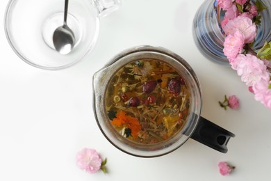 Photo of Flat lay composition with freshly brewed tea and beautiful flowers on white table