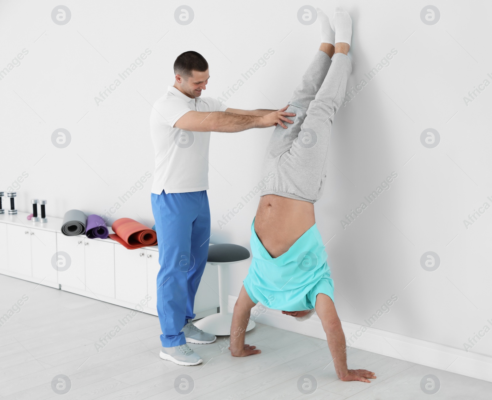 Photo of Professional physiotherapist working with senior patient in rehabilitation center