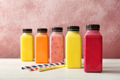 Photo of Bottles with delicious detox smoothies on table