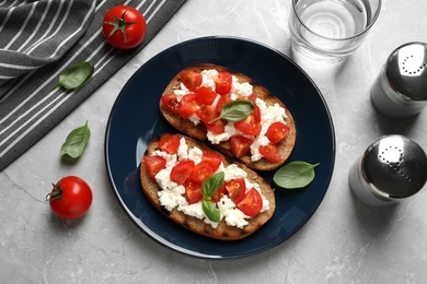 Photo of Flat lay composition with tasty bruschettas on grey table