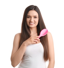 Beautiful young woman with hair brush on white background